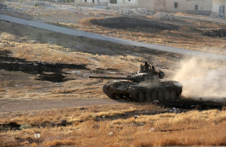 Opposition fighters drive a tank in the Al-Huweiz area on southern outskirts of Aleppo as they battle to break the government seige on the northen Syrian city on August 2, 2016