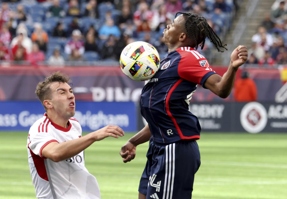 New England Revolution defender Nick Lima, right, defends the ball from Toronto FC defender Kobe Franklin, left, in the second half of an MLS soccer match, Sunday, March 3, 2024, in Foxborough, Mass. (AP Photo/Mark Stockwell)