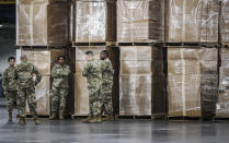 FILE - U.S. National Guard members stand beside crates of medical equipment at the Jacob Javits Center on March 23, 2020, in New York. Gov. Kathy Hochul is sending 50 more New York National Guard members to bolster members out at nursing homes and long-term care facilities. (AP Photo/John Minchillo, File)