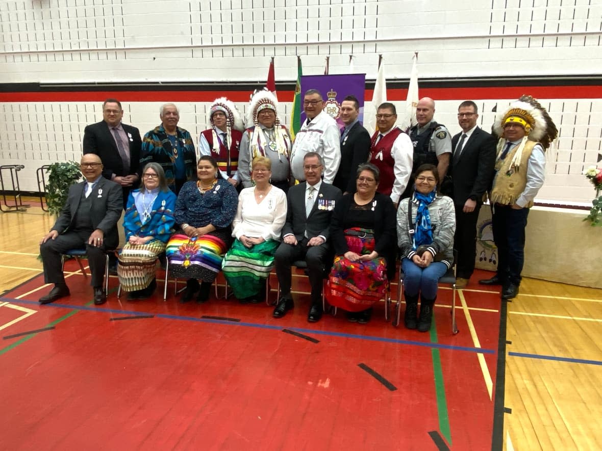 Sixteen people received the Queen's Platinum Jubilee medals at James Smith Cree Nation on Thursday. Saskatchewan Lt.-Gov. Russ Mirasty, seated centre, called the medals symbols of gratitude.  (Trevor Bothorel/CBC - image credit)