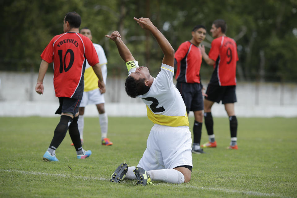 Ernesto Ortiz, from the new semi-professional soccer team "Papa Francisco," or Pope Francis, kneels and gestures to the sky after missing a chance to score against Trefules during their debut game in Lujan, Argentina, Saturday, April 12, 2014. The team named in honor of the Argentine pontiff chose the colors of the Vatican flag for their uniforms. (AP Photo/Victor R. Caivano)