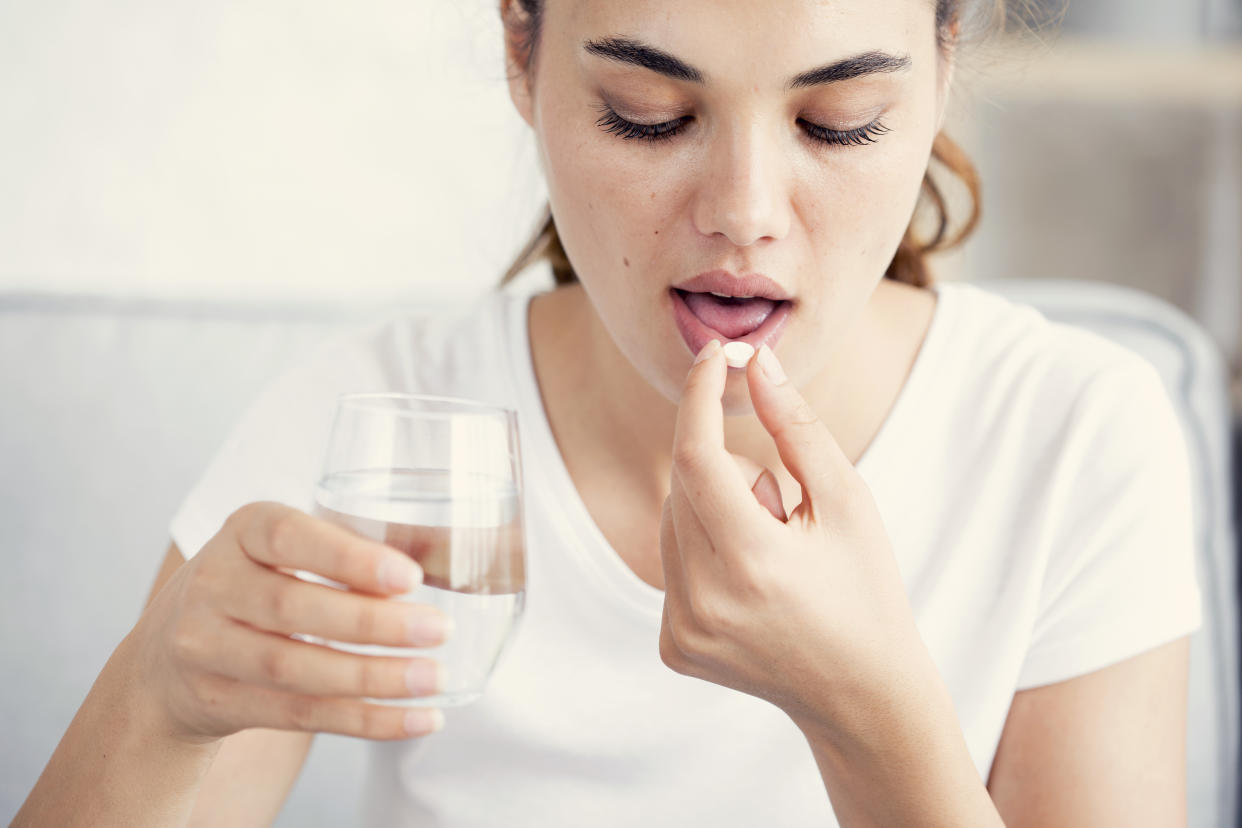 Young woman taking pill