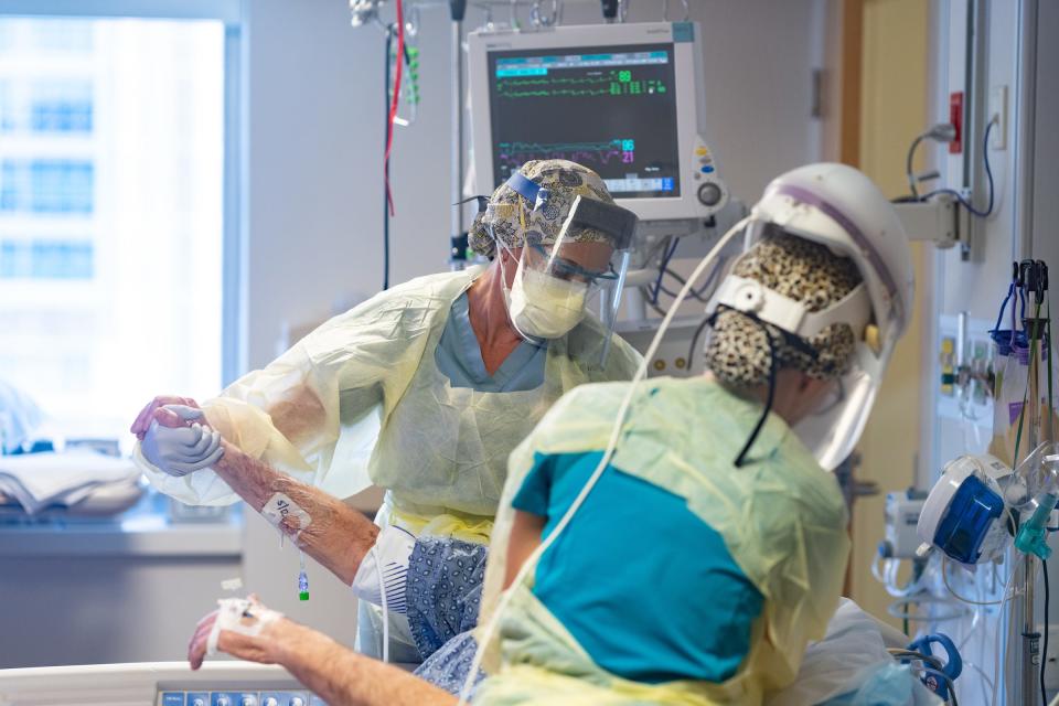 UF Health Shands Hospital Unit 82 nurses, from left, Sarah Graciani and Emily Carter care for a patient with COVID-19.