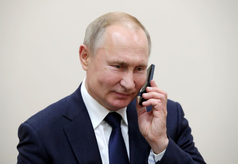 FILE PHOTO: Russian President Vladimir Putin talks on the phone in the settlement of Enem