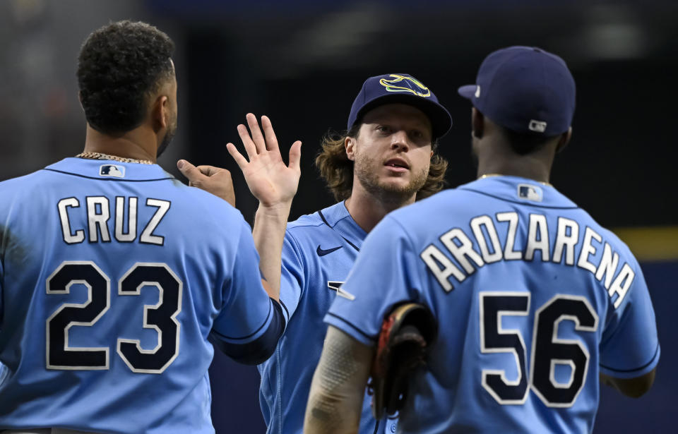 Tampa Bay Rays' Nelson Cruz (23), Brett Phillips and Randy Arozarena (56) celebrate a three-game sweep against the Miami Marlins after a 3-2 win in a baseball game Sunday, Sept. 26, 2021, in St. Petersburg, Fla. (AP Photo/Steve Nesius)