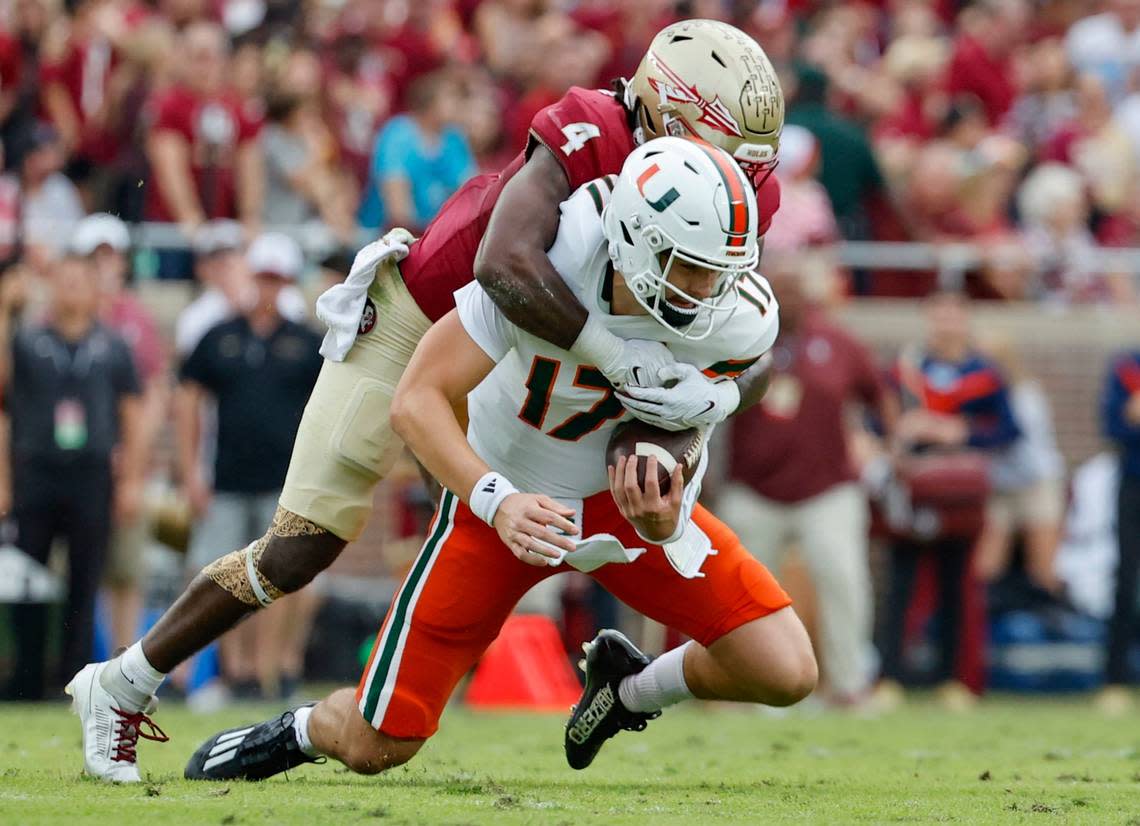 Miami Hurricanes quarterback Emory Williams (17) is sacked by Florida State Seminoles linebacker Kalen DeLoach (4) during the first half at Doak Campbell Stadium in Tallahassee on Saturday, November 11, 2023.