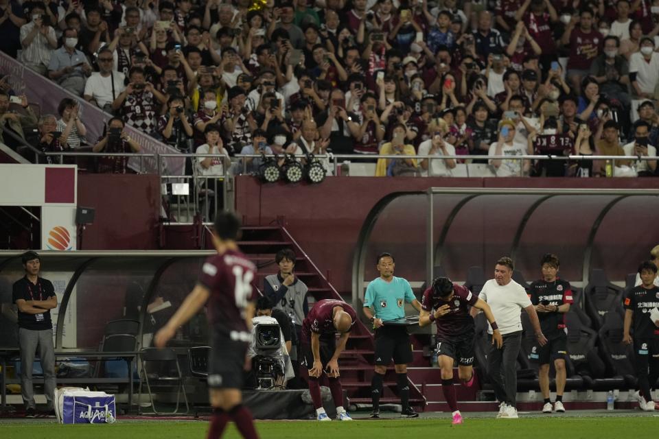 Vissel Kobe midfielder Andres Iniesta, center, bows as he was changed and got off the pitch during the second half of a friendly soccer match against Consadole Sapporo in Kobe, Japan, Saturday, July 1, 2023. The 39-year-old Spanish footballer plays his last match for the Japanese club Saturday. (AP Photo/Hiro Komae)