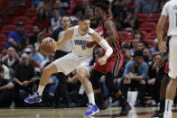 Orlando Magic center Nikola Vucevic (9) drives up against Miami Heat forward Jimmy Butler during the first half of an NBA basketball game Wednesday, March 4, 2020, in Miami. (AP Photo/Wilfredo Lee)
