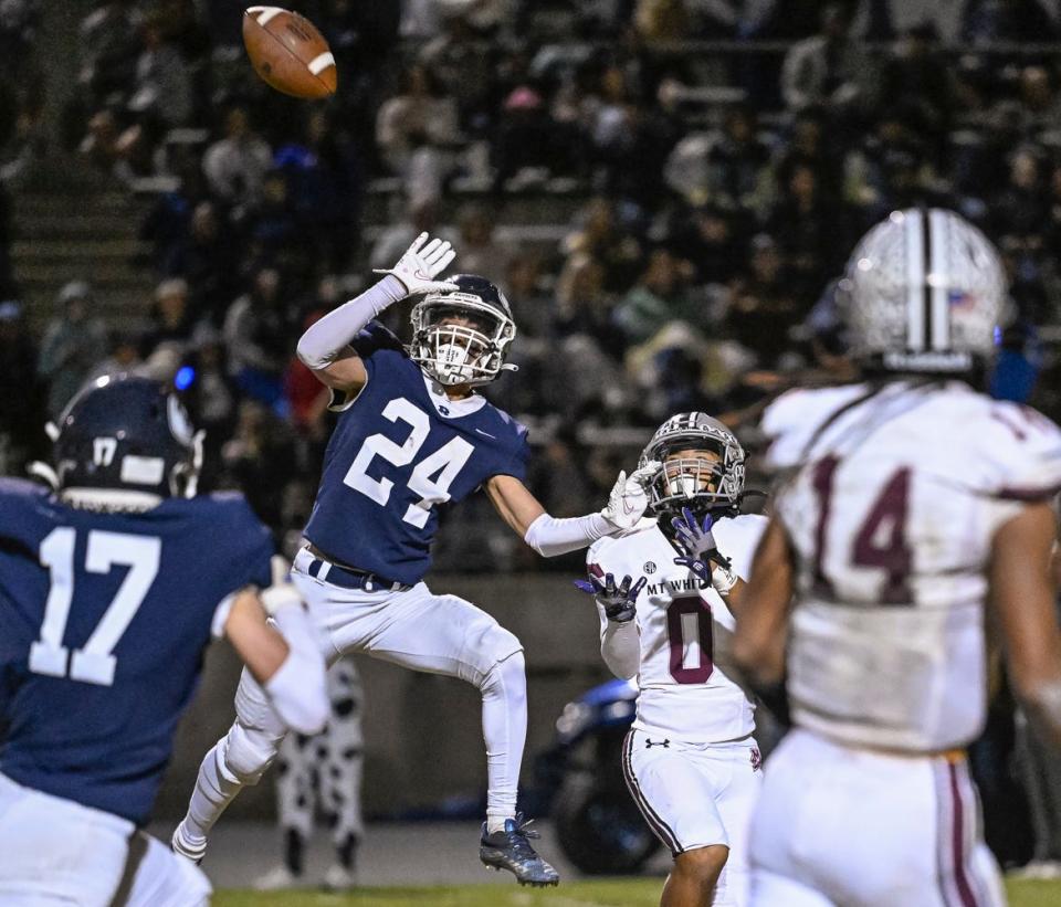 Redwood's Dallas Harris blocks a pass intended for Mt. Whitney's Tallen Xiong in the 68th annual rivalry Cowhide game Friday, October 27, 2023.