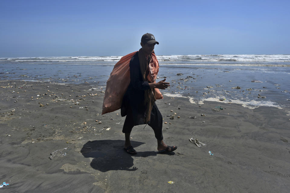 A scavenger searches usable and recyclable material at Clifton beach which closed due to approaching Cyclone Biparjoy, in Karachi, Pakistan, Monday, June 12, 2023. India and Pakistan are bracing for the first severe cyclone this year expected to hit their coastal regions later this week, as authorities halted fishing activities and deployed rescue personnel. (AP Photo/Fareed Khan)