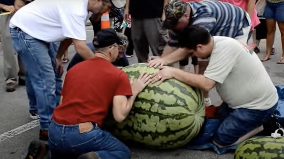 People next to a giant watermelon
