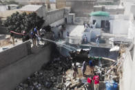 Rescue workers spray water on the part of a Pakistan International Airlines aircraft after it crashed at a residential area in Karachi on May 22, 2020. - A Pakistan passenger plane with more than 100 people believed to be on board crashed in the southern city of Karachi on May 22, the country's aviation authority said. (Photo by Asif HASSAN / AFP) (Photo by ASIF HASSAN/AFP via Getty Images)