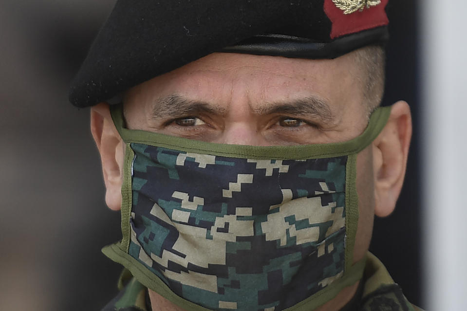 Adm. Remigio Ceballos wears a camouflage face mask as he supervises the unloading of humanitarian aid from China at Maiquetia International Airport amid the spread of the new coronavirus in La Guaira, Venezuela, Saturday, March 28, 2020. (AP Photo/Matias Delacroix)