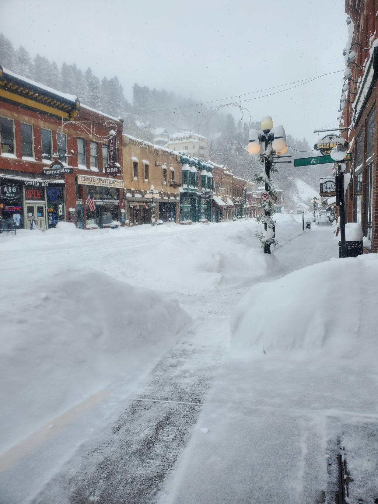 This image provided by Historic Bullock Hotel Manager Vicki Weekly shows snow piled in front of the Historic Bullock Hotel in Deadwood, S.D., on Tuesday, Dec. 13, 2022. (Vicki Weekly via AP)