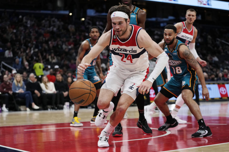 Washington Wizards forward Corey Kispert (24) and Detroit Pistons guard Cory Joseph (18) chase the ball during the first half of an NBA basketball game Tuesday, March 14, 2023, in Washington. (AP Photo/Carolyn Kaster)