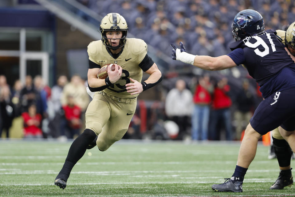 Army quarterback Bryson Daily runs through a hole past Navy defensive tackle Clay Cromwell during the first quarter of an NCAA football game at Gillette Stadium Saturday, Dec. 9, 2023, in Foxborough, Mass. (AP Photo/Winslow Townson)