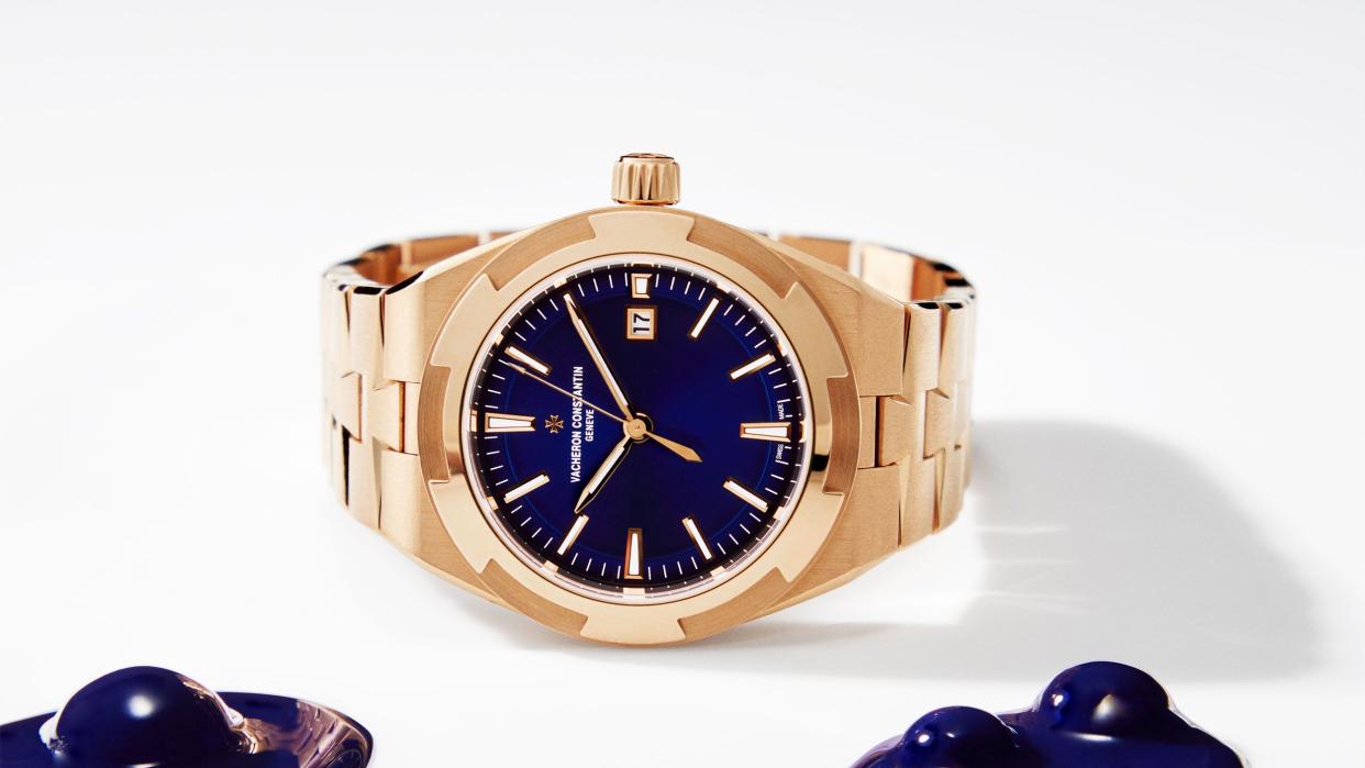 a gold tone watch with blue lapis face and some similar blue blobs next to itl