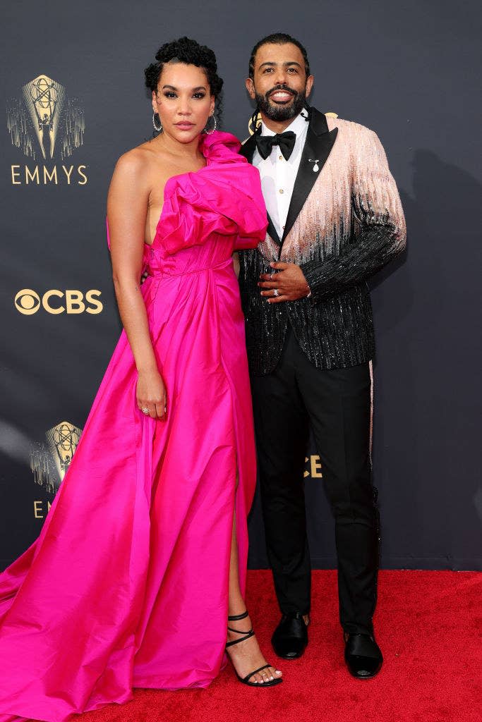 Emmy Raver-Lampman wears a one shoulder brightly colored gown and Daveed Diggs wears a dark suit