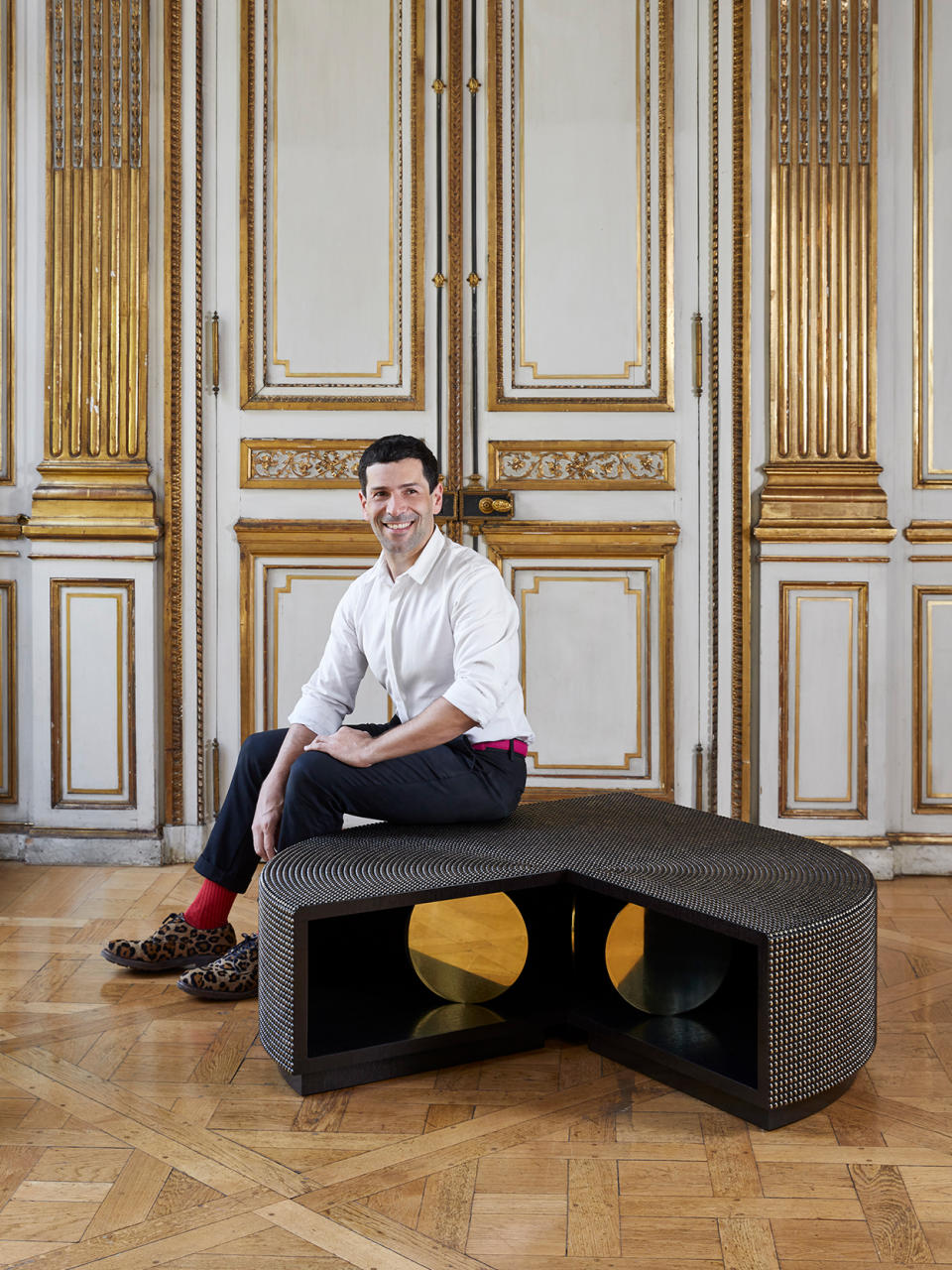 Alexis Mabille with a table from his debut furniture line. - Credit: Francis Amiand/Courtesy of Beaubow Editions