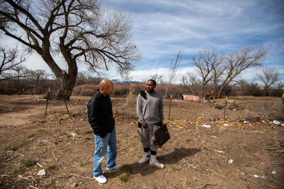 Two men talk outdoors