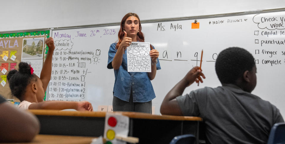 First and second grade teacher Ayla Nash explains how to do a worksheet Monday, June 26, 2023, at Holy Angels Catholic School during summer school in Indianapolis.