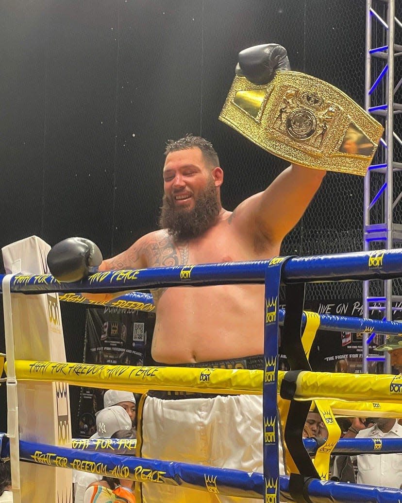 Jonathan "The King" Guidry holds up the championship belt he earned by winning the North American Boxing Association's gold title with a seventh-round knockout of Dacarree “Mac Truck” Scott, Saturday, June 11.
