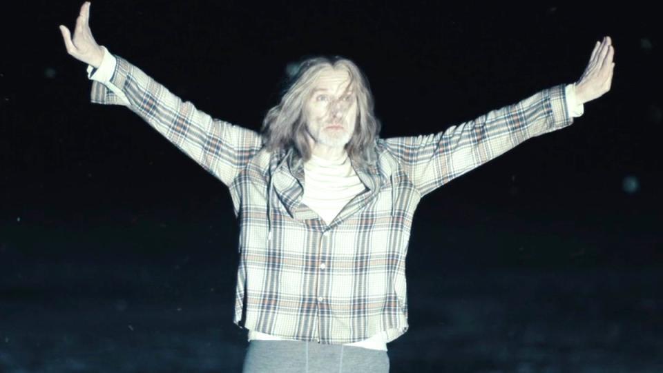 A ghost with a plaid shirt holds his arms out white on True Detective: Night Country