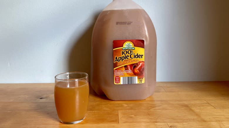 gallon of Nature's Nectar cider with glass cup