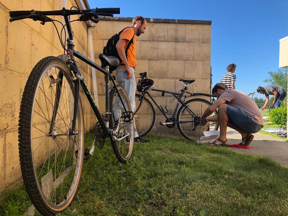 Volunteer Ben Barwick, right, helps Rob Nerenberg repair his bike July 13, 2022, in the courtyard of the new home for the South Bike Garage, Indiana 933 and Angela Boulevard.