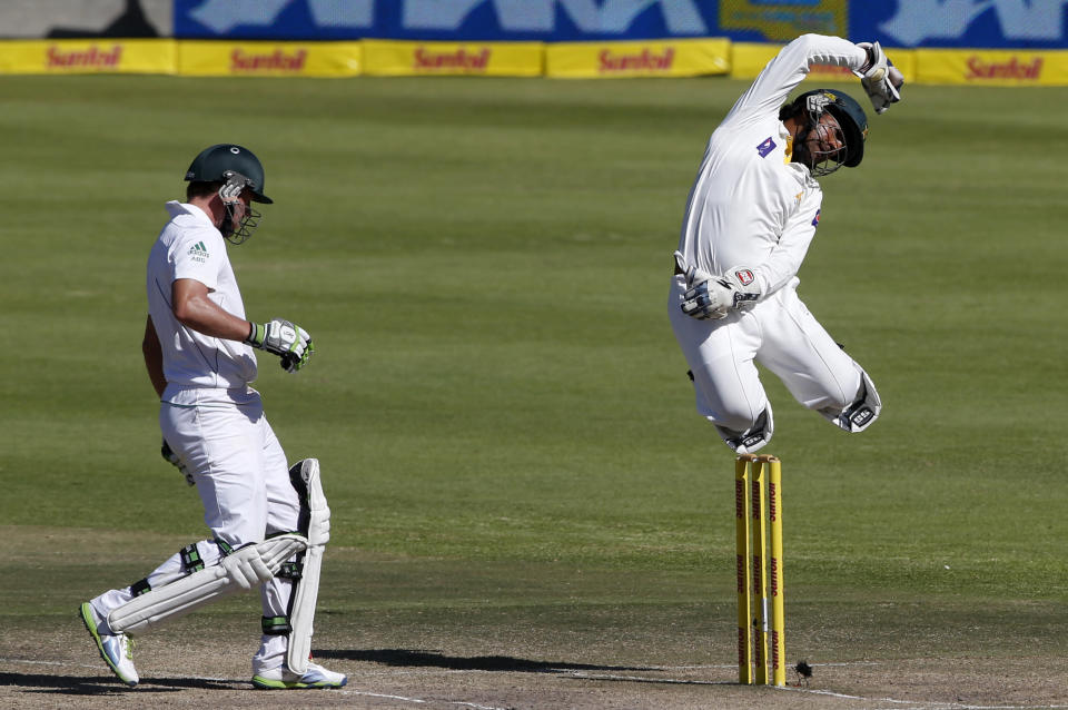 Pakistan's Sarfraz Ahmed jumps for the ball as South Africa's AB de Villiers (L) makes his ground on the fourth day of the second cricket test match in Cape Town, February 17, 2013. REUTERS/Mike Hutchings (SOUTH AFRICA - Tags: SPORT CRICKET TPX IMAGES OF THE DAY) - RTR3DX63