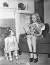 <p>The <em>Some Like it Hot</em> star reads a children's book to the young daughter of a fellow Hollywood studio player.</p>