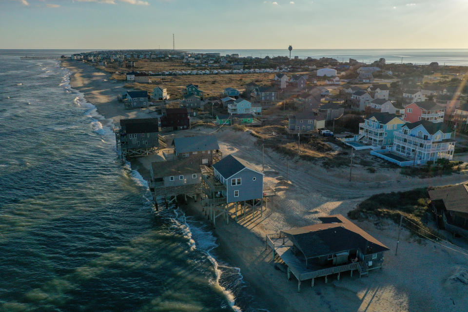 Two beachfront homes are seen beginning to fall into the ocean in North Carolina.