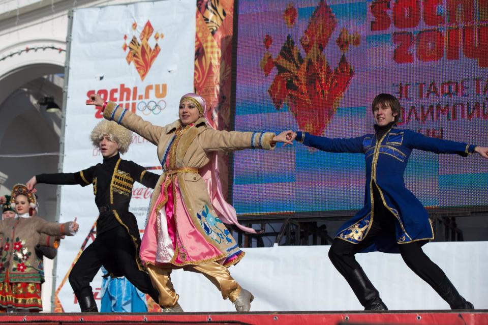 In this photo taken on Sunday, Jan. 26, 2014 and provided by Olympictorch2014.com, dancers wearing national costumes perform during the torch relay in the southern Russian city of Astrakhan. The relay for the Sochi Winter Games, which began on Oct. 7 2013 in Moscow, will pass through many cities that showcase the historical, cultural and ethnic richness of Russia. (AP Photo/Olympictorch2014.com)