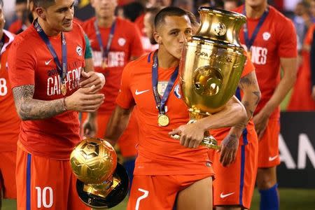 Jun 26, 2016; East Rutherford, NJ, USA; Chile forward Alexis Sanchez (7) kisses the championship trophy after winning the championship match of the 2016 Copa America Centenario soccer tournament against Argentina at MetLife Stadium. Chile defeated Argentina 0-0 (4-2). Mandatory Credit: Brad Penner-USA TODAY Sports