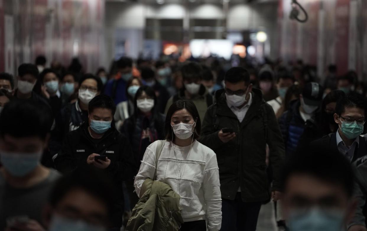 <span class="caption">Residents of Hong Kong wear masks as they make their commutes. </span> <span class="attribution"><span class="source">AP Photo/Kin Cheung</span></span>