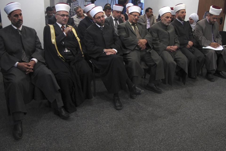 In this photo taken Thursday, Aug. 30, 2012, a row of Islamic law judges, identifiable by their red-and-white turbans and robes, listen to a press conference announcing changes to Palestinian divorce law in the West Bank city of Ramallah. (AP Photo/Diaa Hadid)