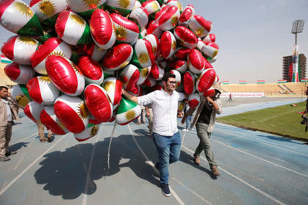 A man carries balloons decorated with Kurdistan flags before the start of a rally calling to vote yes in the coming referendum, Erbil, Iraq September 22, 2017. REUTERS/Azad Lashkari