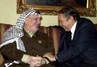 FILE - In this March 26, 2001 file photo, Palestinian leader Yasser Arafat welcomes Algerian President Abdelaziz Bouteflika during their meeting at Royal Palace in Amman, Jordan. Former Algerian President Bouteflika, who fought for independence from France in the 1950s and 1960s and was ousted amid pro-democracy protests in 2019 after 20 years in power, has died at age 84, state television announced Friday, Sept. 17, 2021. (AP Photo/Hussein Hussein, File)