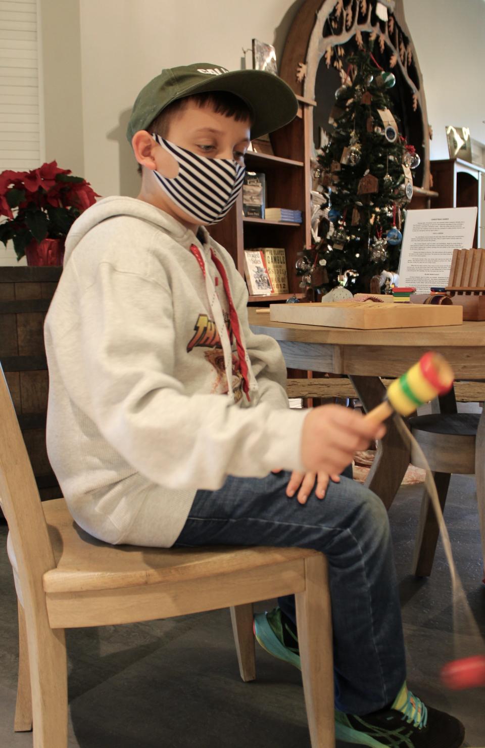 Levi Lee, 9, of Monroe plays bilboquet, a ball and cup game, at French Noel, a free event hosted by staff members and volunteers at River Raisin National Battlefield Visitor Center, 333 N. Dixie Hwy.