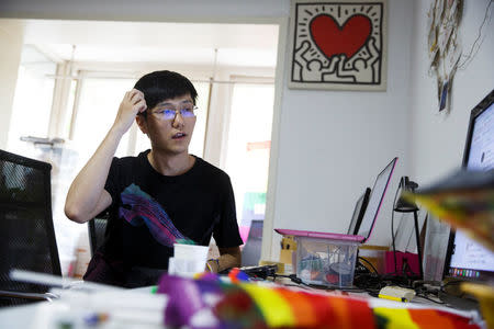 Liu Yifu, an organiser of a 5.17 km run to mark International Day Against Homophobia, sits in his office in Beijing, China, May 17, 2018. REUTERS/Thomas Peter