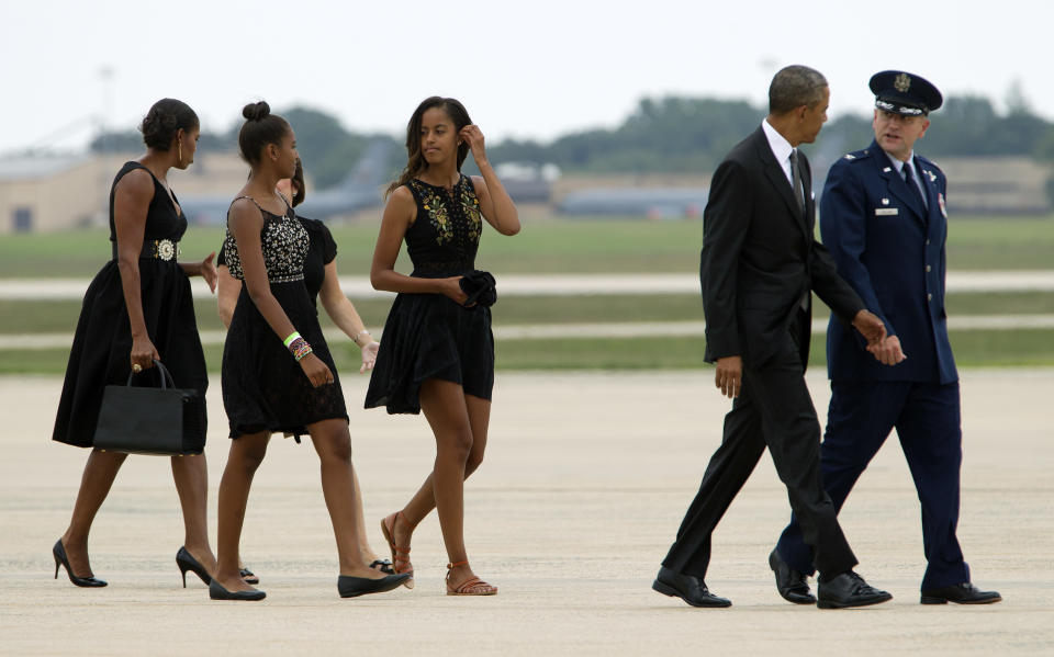 President Barack Obama speaks with Col. John C. Millard, Commander, 89th Airlift Wing, accompanied by his daughters, Malia and Sasha, and first lady Michelle Obama, upon their arrival at Andrews Air Force Base in Md., on Saturday, Aug. 30, 2014, en route to Westchester County, N.Y., to attend the wedding ceremony of White House Chef Sam Kass and MSNBC host Alex Wagner. 