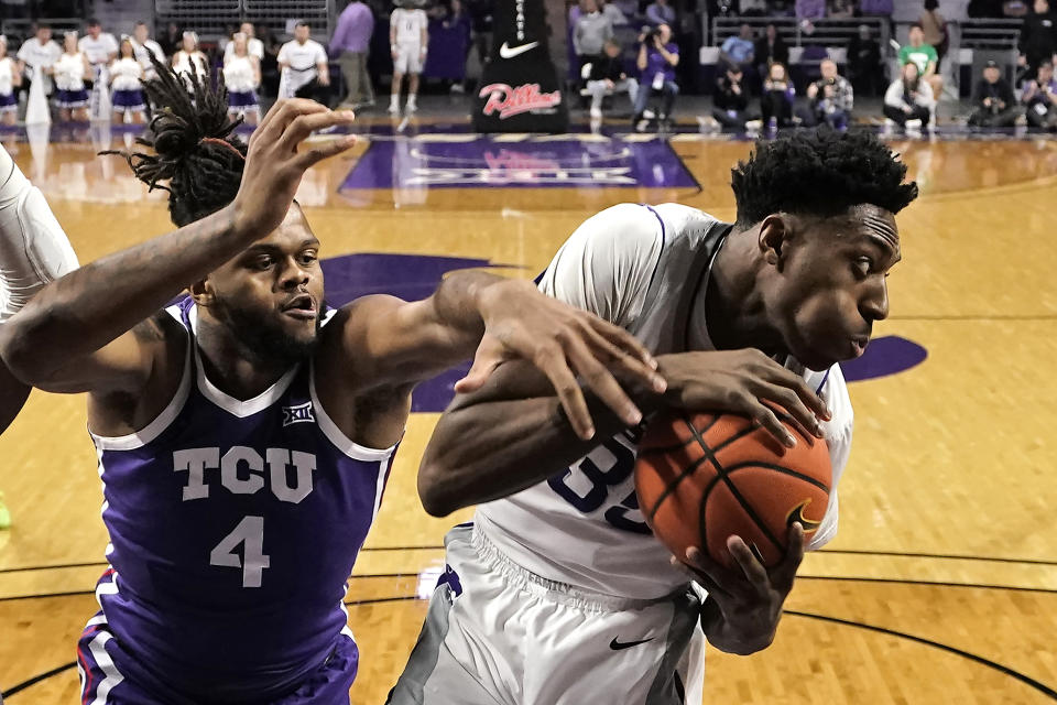 TCU center Eddie Lampkin Jr. (4) tries to steal the ball from Kansas State forward Nae'Qwan Tomlin (35) during the first half of an NCAA college basketball game Tuesday, Feb. 7, 2023, in Manhattan, Kan. (AP Photo/Charlie Riedel)