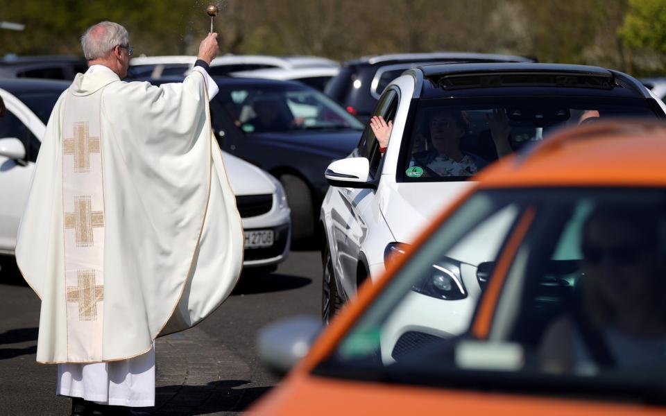 Mandatory Credit: Photo by FRIEDEMANN VOGEL/EPA-EFE/Shutterstock (10610921w) Pastor Frank Heidkamp blesses the vehicle and sprinkles it with holy water after the Catholic Easter service at a drive-in cinema in Duesseldorf, Germany, 12 April 2020. In the new drive-in cinema on the parking lot of exhibition grounds, three church services will be held during the Easter holidays. Churches in Germany have been closed due to the ongoing pandemic of the COVID-19 disease caused by the SARS-CoV-2 coronavirus. Easter Sunday is one of the most important holidays on the Christian calendar, as it marks the resurrection of Jesus Christ. Catholic Easter services drive-in cinema in Duesseldorf, Germany - 12 Apr 2020 - FRIEDEMANN VOGEL/EPA-EFE/Shutterstock