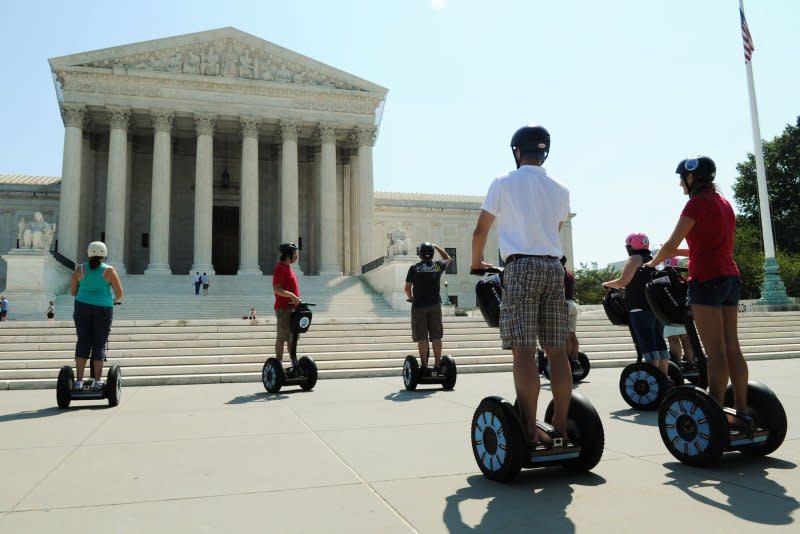 A Segway tour stops outside the U.S. Supreme Court building in Washington on August 7, 2010. On September 27, 2010, Jimi Heselden, 62, manufacturer of the upright Segway scooter, was killed when he apparently lost control of one of the two-wheeled, self-balancing machines and ran over a cliff into a river. File Photo by Alexis C. Glenn/UPI