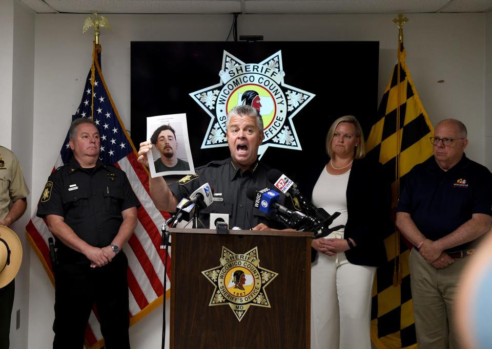 Sheriff Mike Lewis holds up a photo of the suspect apprended for the death of Deputy First Class Glenn Hillard during a a press conference Monday, June 13, 2022, at the Wicomico County Sheriff's Office in Salisbury, Maryland.