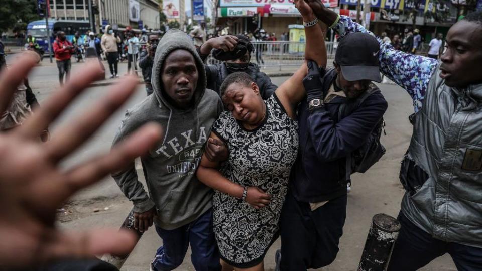 A woman (C) who suffered tear gas inhalation is rescued during new demonstrations in Nairobi, on July 16, 2024. 