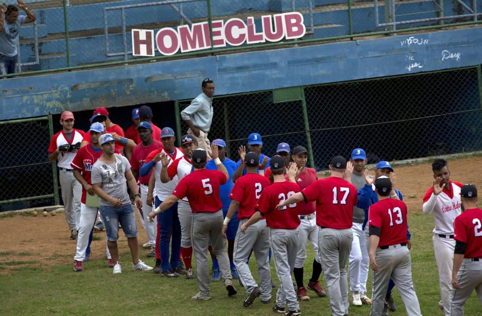 Baseball players from the University of Tampa, left, greet players from the Cuban youth squad at the end of their exhibition game in Havana, Cuba, Wednesday, Jan. 15, 2014. The visitors scraped out a hard-fought win, but the encounter was more about bridging the vast gulf between these neighboring nations that disagree on just about everything except their shared love of the game. (AP Photo/Ramon Espinosa)