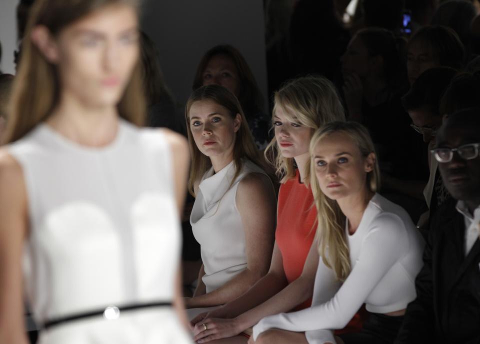 A model, far left, walks the runway wearing a design from the Calvin Klein Spring 2013 collection as actresses Amy Adams, Emma Stone and Diane Kruger watch at Fashion Week in New York, Thursday, Sept. 13, 2012. (AP Photo/Kathy Willens)