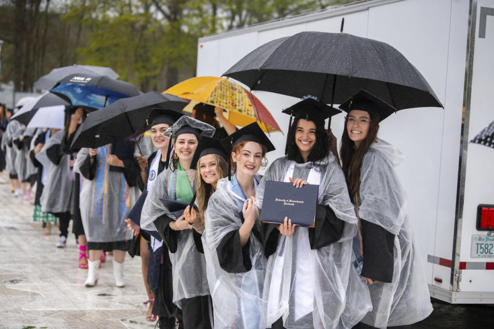 In this photo provided by University of Massachusetts Dartmouth, graduate students hold their diplomas at the graduation ceremony Thursday, May 16, 2024, in Dartmouth, Mass. Billionaire Robert Hale gifted graduates at the University of Massachusetts Dartmouth each with $1,000., with the condition that they give $500 away. Hale revealed the gift to more than 1,100 graduates. (Karl Christoff Dominey/University of Massachusetts Dartmouth via AP)