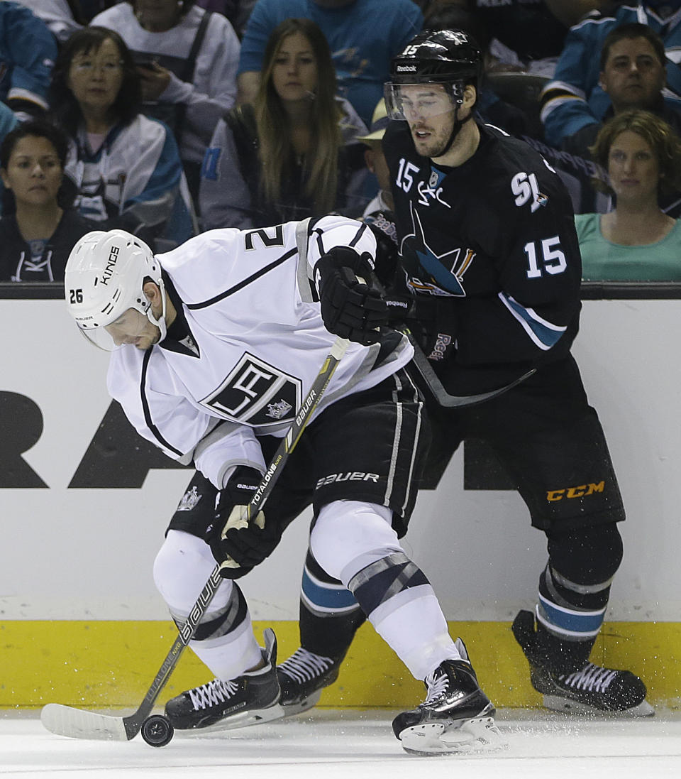 Los Angeles Kings' Slava Voynov, left, and San Jose Sharks' James Sheppard vie for the puck during the first period of Game 1 of an NHL hockey first-round playoff series Thursday, April 17, 2014, in San Jose, Calif. (AP Photo/Ben Margot)